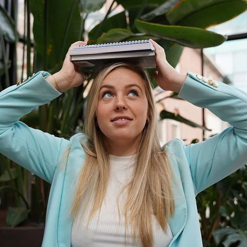 Gemotiveerde jonge zorgprofessional met notitieboek op het hoofd, klaar voor een leven lang leren via Medic Academy.